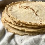 a stack of corn tortillas stacked in a clean dish towel