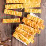 thin strips of ligurian focaccia on a sheet pan and on a white rectangular plate.