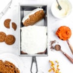 pumpkin gingerbread cake in a loaf pan with cream cheese frosting
