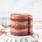 a mocha hazelnut layer cake with a slice being taken out of it on a cake lifter spatula