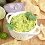 a small cocotte of guacamole garnished with cilantro.