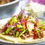 a close up photo of an assembled taco on a plate