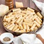 one skillet cacio e pepe in a pan on a wooden table