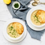 an overhead shot of two bowls of soup with cheese crisps