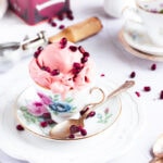 pomegranate oolong tea ice cream in a tea cup topped with pomegranate seeds