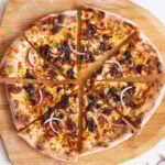 bbq pulled pork pizza on a pizza peel.