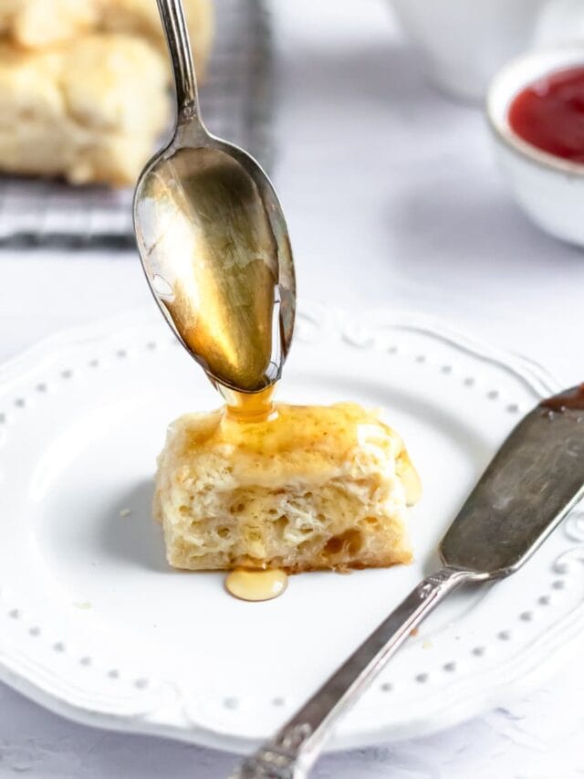 spooning honey over a mini biscuit