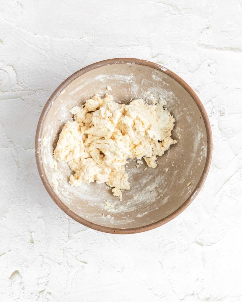 clumpy buttermilk biscuit dough in a mixing bowl.