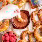 dipping a pretzel in raspberry honey mustard dip
