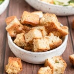 a small white bowl with focaccia croutons in it.