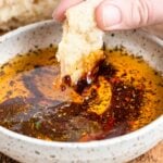 dipping a torn piece of bread in the seasoned olive oil dip.
