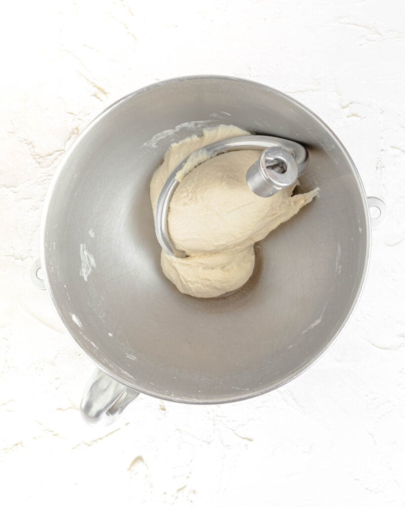 The dough after kneading with the dough hook is smooth and elastic, pulling clean from the side of the bowl.