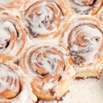 closeup of icing covered cinnamon rolls.