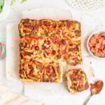 pepperoni pizza pinwheels with the bottom right roll torn off the loaf.