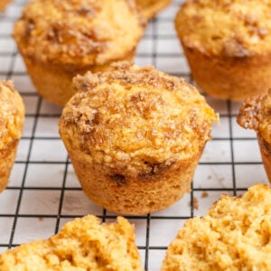 close up of a cornbread muffin with brown sugar topping on a black wire rack.