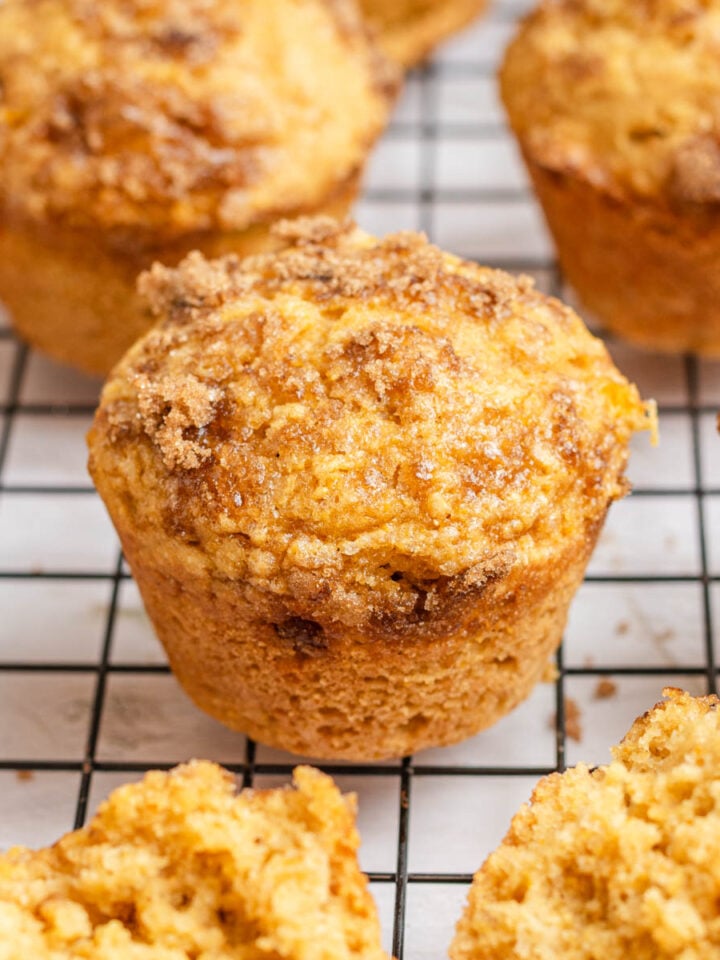 close up of a cornbread muffin with brown sugar topping on a black wire rack.